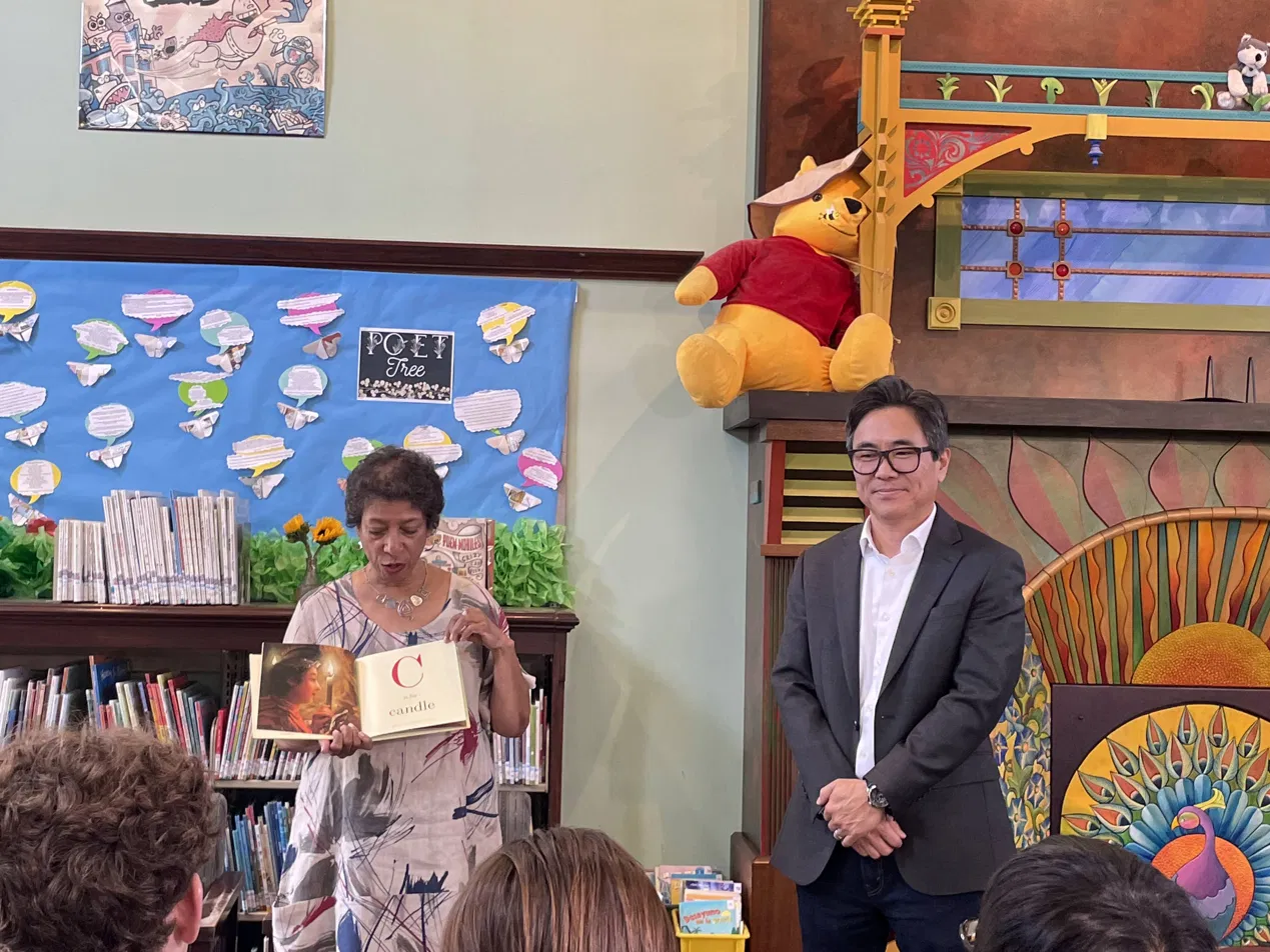 A poet reading from an open book at the Pico Union Library