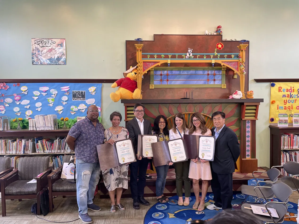 A group of community members holding certificates of recognition